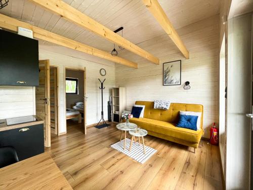 a living room with a yellow couch and a table at Brzozowisko Tuchomko in Tuchomko