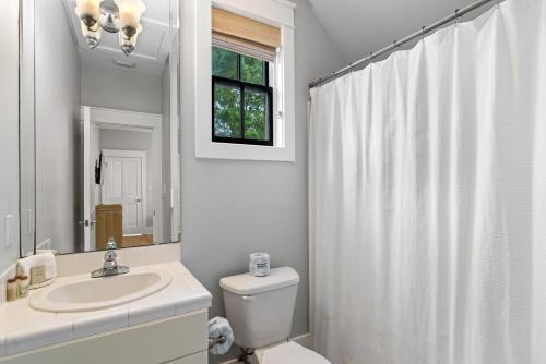 a bathroom with a toilet and a sink and a mirror at 13 Lake District Lane in Santa Rosa Beach