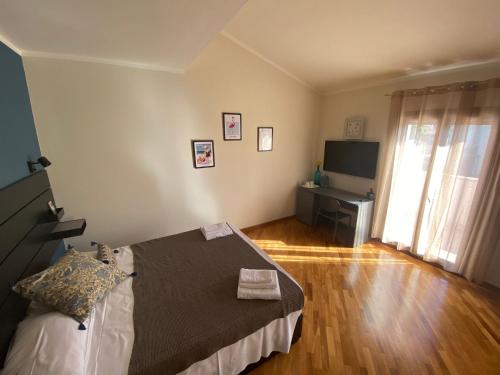 a bedroom with a bed and a television in it at Flamingo Poetto in Quartu SantʼElena