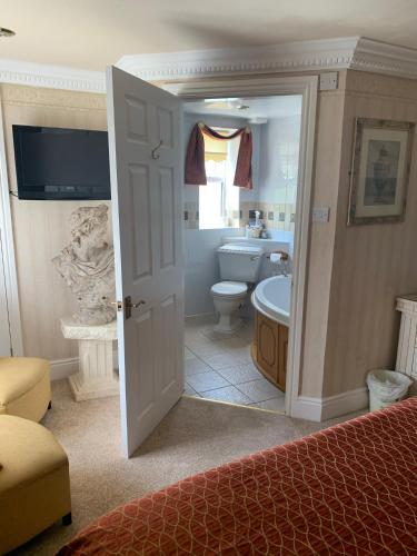 a bedroom with a bathroom with a toilet and a sink at The Old Coach House in Blackpool