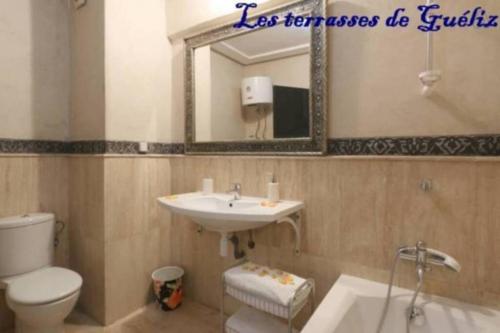 y baño con lavabo, aseo y espejo. en Les terrasses de Gueliz, en Marrakech