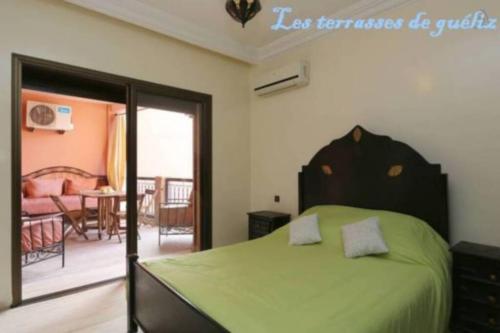 1 dormitorio con 1 cama verde y sala de estar en Les terrasses de Gueliz, en Marrakech