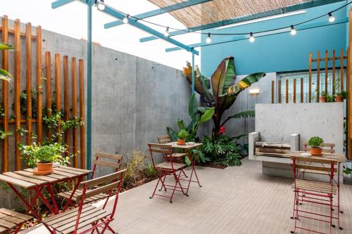 an outdoor patio with tables and chairs and plants at Casa d´Avó Dalina in Figueira da Foz