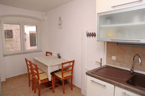 a kitchen with a table and chairs and a sink at Sailboat house in Korčula