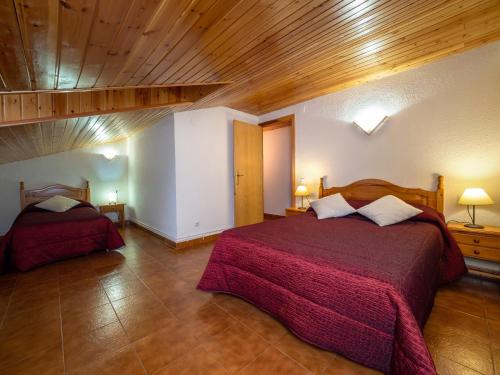 1 dormitorio con 2 camas y techo de madera en Casa rural Quintana - Montanuy en Montanúy