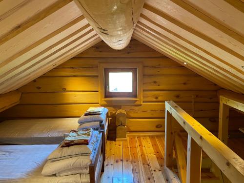 1 dormitorio en una cabaña de madera con cama y ventana en Suislepa Puhkemajad, en Suislepa