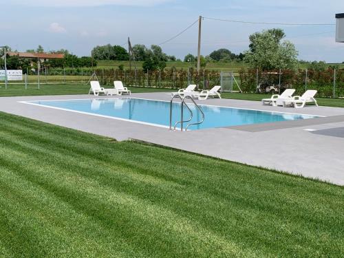 a swimming pool with lounge chairs and a lawn at Country House Campofiore in Pontelongo