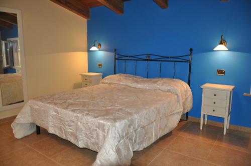 1 dormitorio con cama y pared azul en Agriturismo Le Vigne, en Fermo