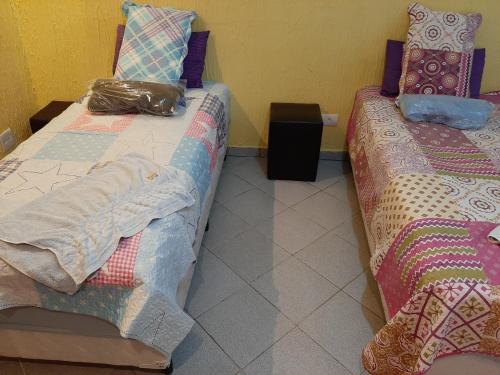 two beds sitting next to each other in a room at Pousada Exuberance in Diadema