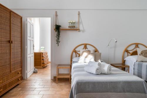 two beds in a room with white walls at Il pergolato sul mare in Monopoli