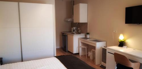 a small room with a bed and a kitchen at Pensiunea Groza in Târgu Jiu