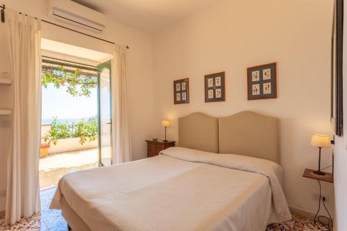 a bedroom with a bed and a sliding glass door at il Pettirosso in Positano in Positano
