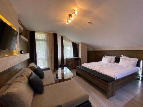 a bedroom with a bed and a couch at Deluxe 707 in Borovets