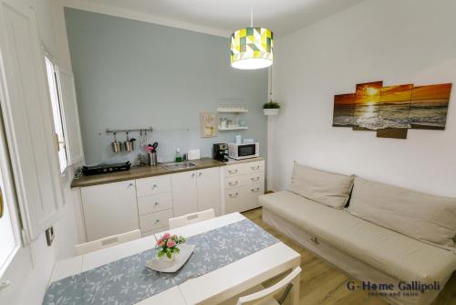 G-Home Gallipoli rooms and suite في غالّيبولي: غرفة معيشة بها أريكة وطاولة