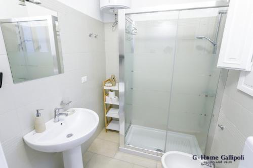 G-Home Gallipoli rooms and suite في غالّيبولي: حمام أبيض مع دش ومغسلة