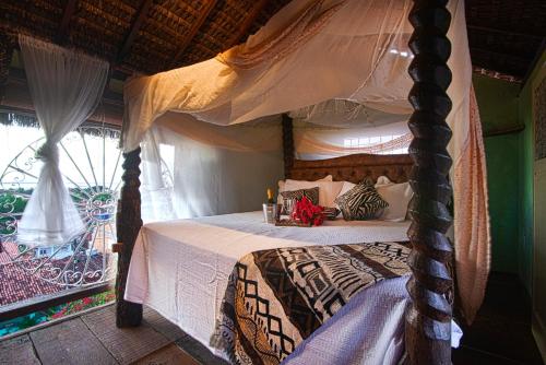 a bedroom with a canopy bed and a window at hostel Mama Africa 2 in Gamboa