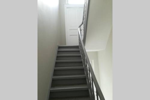 a staircase in a white room with a stair case at Appartement 20 min du Circuit Spa-Francorchamps, in Verviers