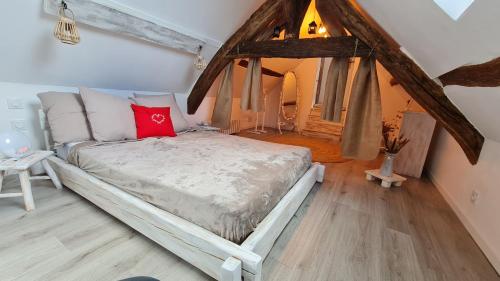 een slaapkamer met een groot bed op zolder bij L'Evidence in Saint-Aignan