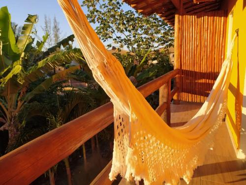 a hammock on a balcony with plants at Pousada dos Cardeais in Barra Grande
