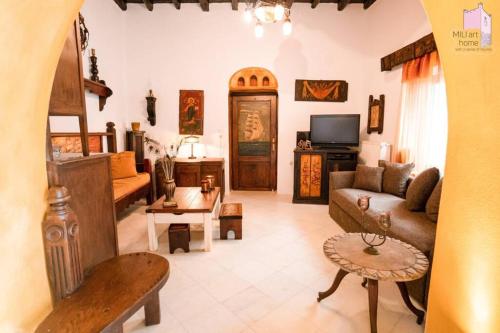 uma sala de estar com um sofá e uma televisão em Mili Art Home em Naxos Chora