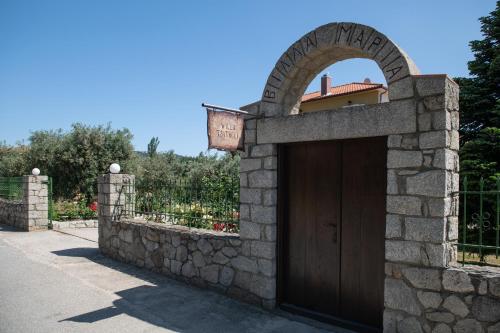 a gate with a wooden door in a stone wall at Villa Tsitreli in Sikia