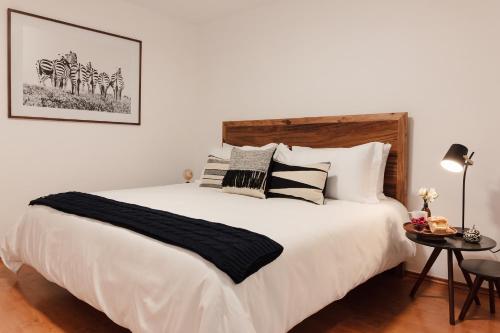 a bedroom with a large white bed with pillows at Jardín Roma By The Local Way in Mexico City