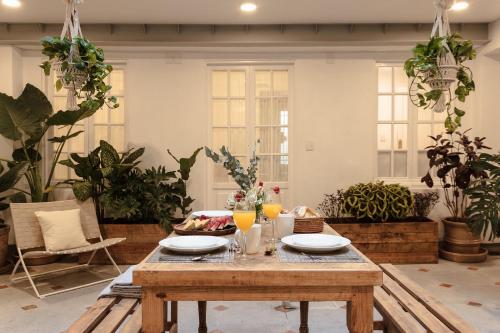 a wooden table with plates and drinks on top of it at Jardín Roma By The Local Way in Mexico City