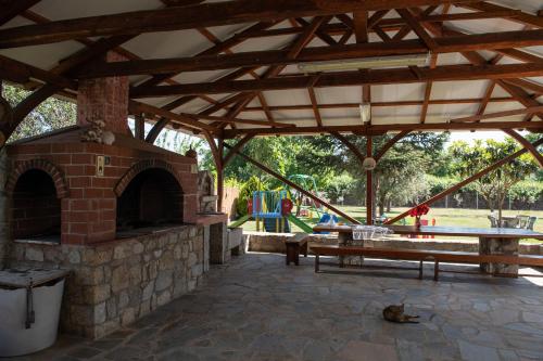 an outdoor pavilion with a picnic table and a brick oven at Villa Tsitreli in Sikia