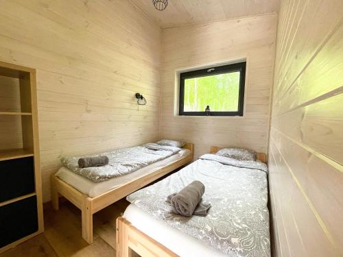 two beds in a small room with a window at Brzozowisko Tuchomko in Tuchomko