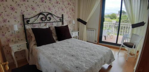 Un dormitorio con una cama blanca y un balcón. en La guardia ll, en A Guarda
