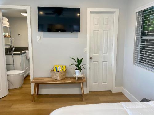 a bedroom with a table and a television on a wall at Steps To The Beach, Pacific City and Main Street - Studio in Huntington Beach