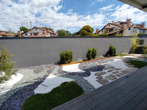 a garden with a retaining wall and a stone pathway at B&B Le Nazioni in Lido delle Nazioni