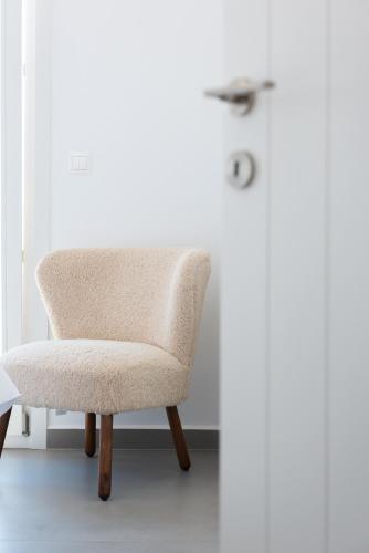 a chair in a room with a white wall at The Be House in Sifnos