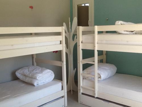 two bunk beds with white pillows in a room at Le temps des cerises in Méthamis