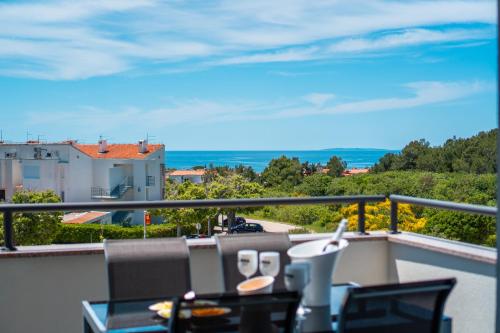 a balcony with a table and chairs and a view of the ocean at LUNA Residence in Novalja