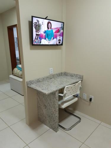a room with a counter with a tv on the wall at Apto JK Universitário - Express in Santa Cruz do Sul