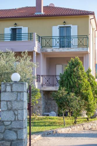 a house with two balconies and a stone wall at Villa Tsitreli in Sikia