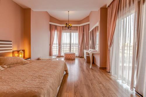 a bedroom with a bed and a desk and windows at VISTA Villa in Belek