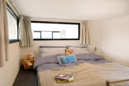 um quarto com dois ursos de peluche sentados numa cama em Cube Elite mit Meerblick am Strand im EuroParcs Bad Hoophuizen em Hulshorst