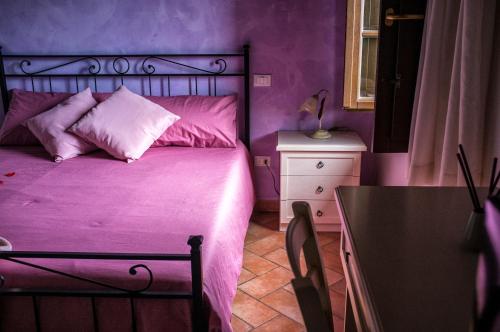 a purple bedroom with a bed and a table at Il Casale di David in Pontedera