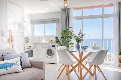 a kitchen and living room with a table and chairs at Hanami Avenida de España Sea Front in Estepona