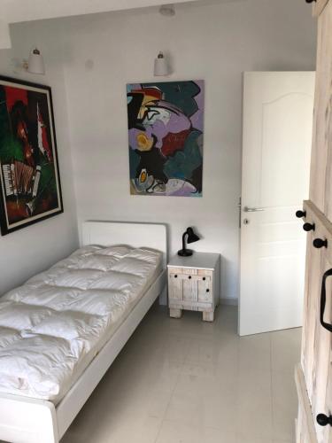 ein Schlafzimmer mit einem Bett und einem Gemälde an der Wand in der Unterkunft Artistic Luxury in Skopje