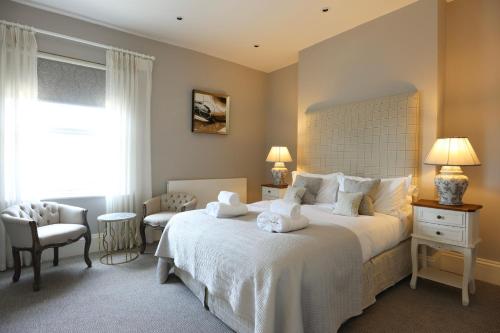 a bedroom with a large white bed and a window at Tyndall Villa Boutique B&B in Bath