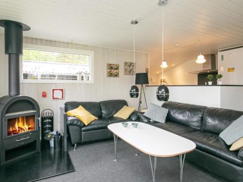 sala de estar con sofá y chimenea en 6 person holiday home in Bl vand, en Blåvand