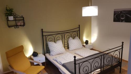 1 dormitorio con 1 cama negra y 1 silla en FeWo -Kleines Moselglück- in Winningen bei Koblenz, en Winningen