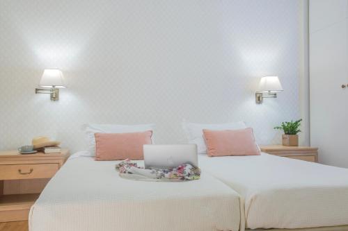 
a hotel room with two beds and two lamps at Delice Hotel - Family Apartments in Athens
