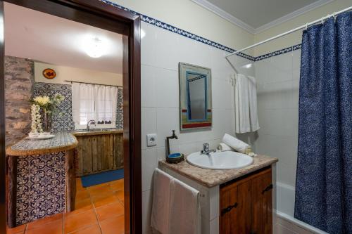 een badkamer met een wastafel en een spiegel bij Chalet do Monte no Porto Moniz by Madeira Sun Travel in Porto Moniz