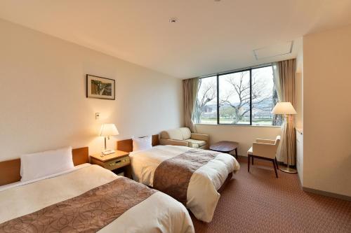 Säng eller sängar i ett rum på KKR Kyoto Kuniso