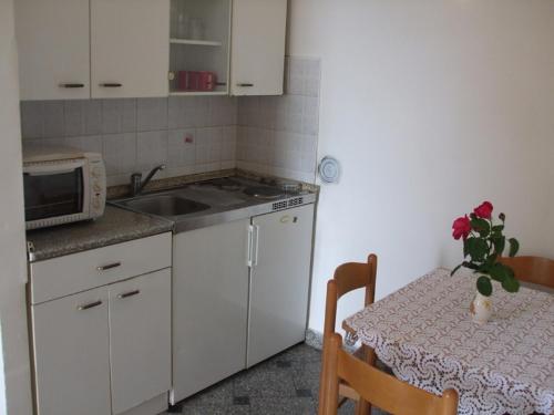 een kleine keuken met een tafel en een magnetron bij Apartment in Ika with sea view, terrace, air conditioning, WiFi (3699-2) in Ika