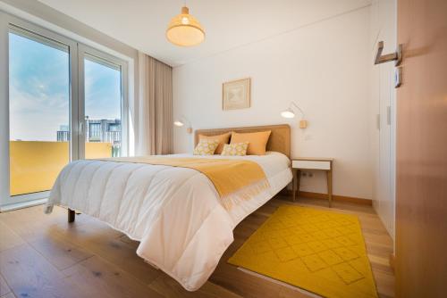 una camera da letto con un letto grande con una grande finestra di Casa das Musas 2 a Porto
